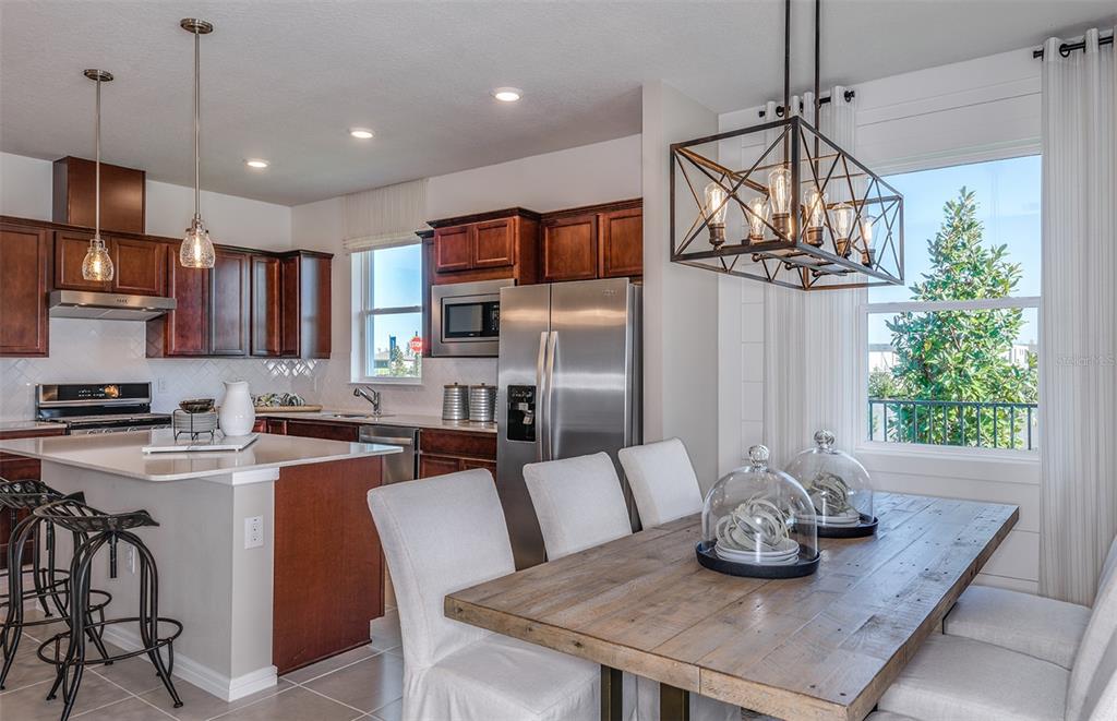 13693 Cyn Rdg Road Spring Hill, FL 34610 - Photo 3 of 29 a kitchen with stainless steel appliances granite countertop a sink a stove a refrigerator cabinets and a dining table