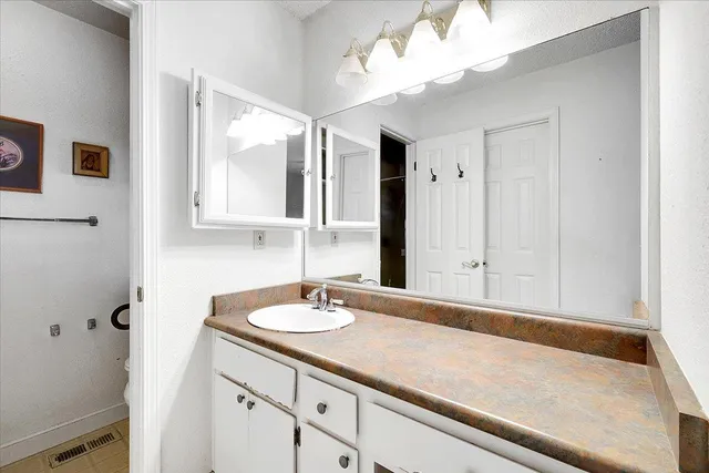 a bathroom with a sink vanity and a mirror