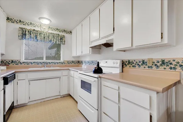 a kitchen with granite countertop white cabinets and white appliances