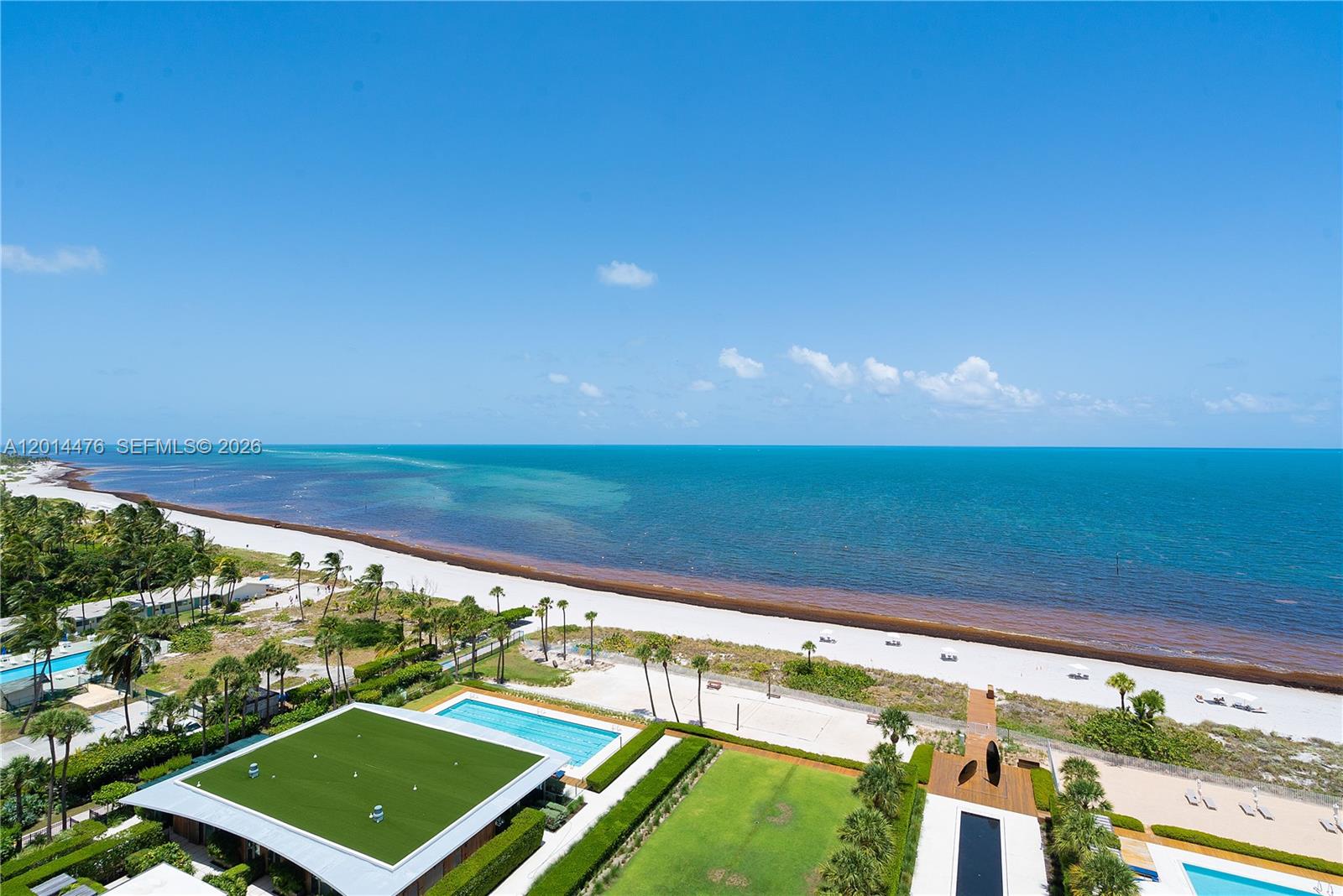 360 Ocean Drive, Unit 1106S Key Biscayne, FL 33149 - Photo 29 of 67 Oceanfront View – A sweeping elevated view captures the beach, turquoise water, and beautifully landscaped outdoor amenities below. The wide horizon and vibrant coastal setting create a striking visual connection to the ocean.