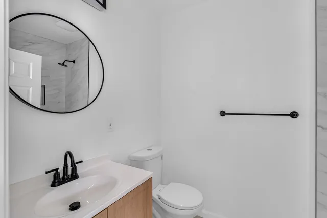 a bathroom with a sink a mirror a toilet and a shower