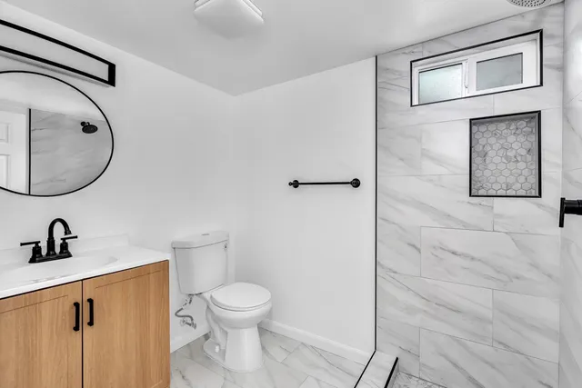 a bathroom with a toilet sink and mirror