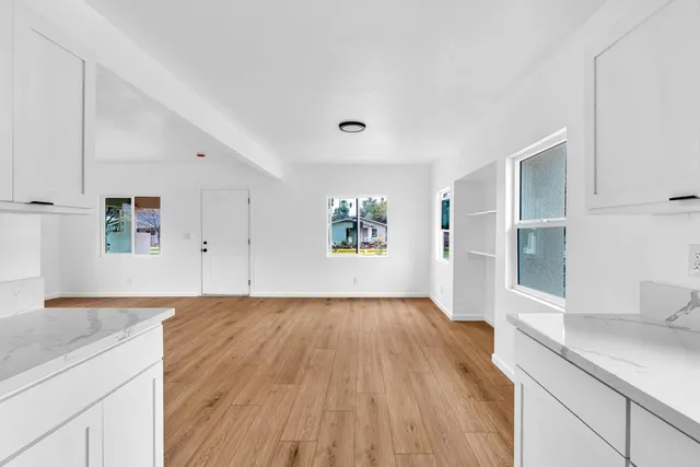 an empty room with wooden floor and windows