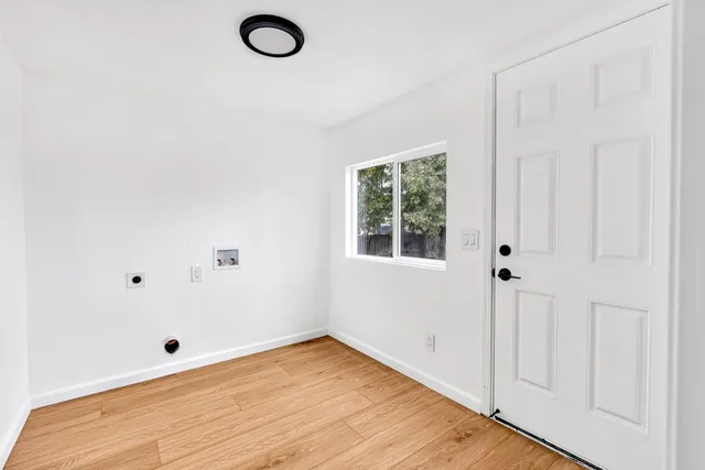 a view of a room with wooden floor and white walls