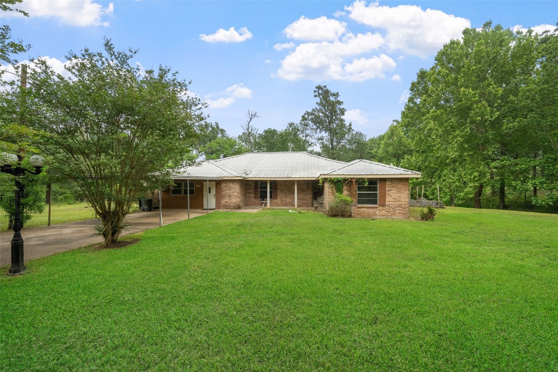 101 Walnut Coldspring, TX 77331 - Photo 1 of 37 a front view of a house with a garden