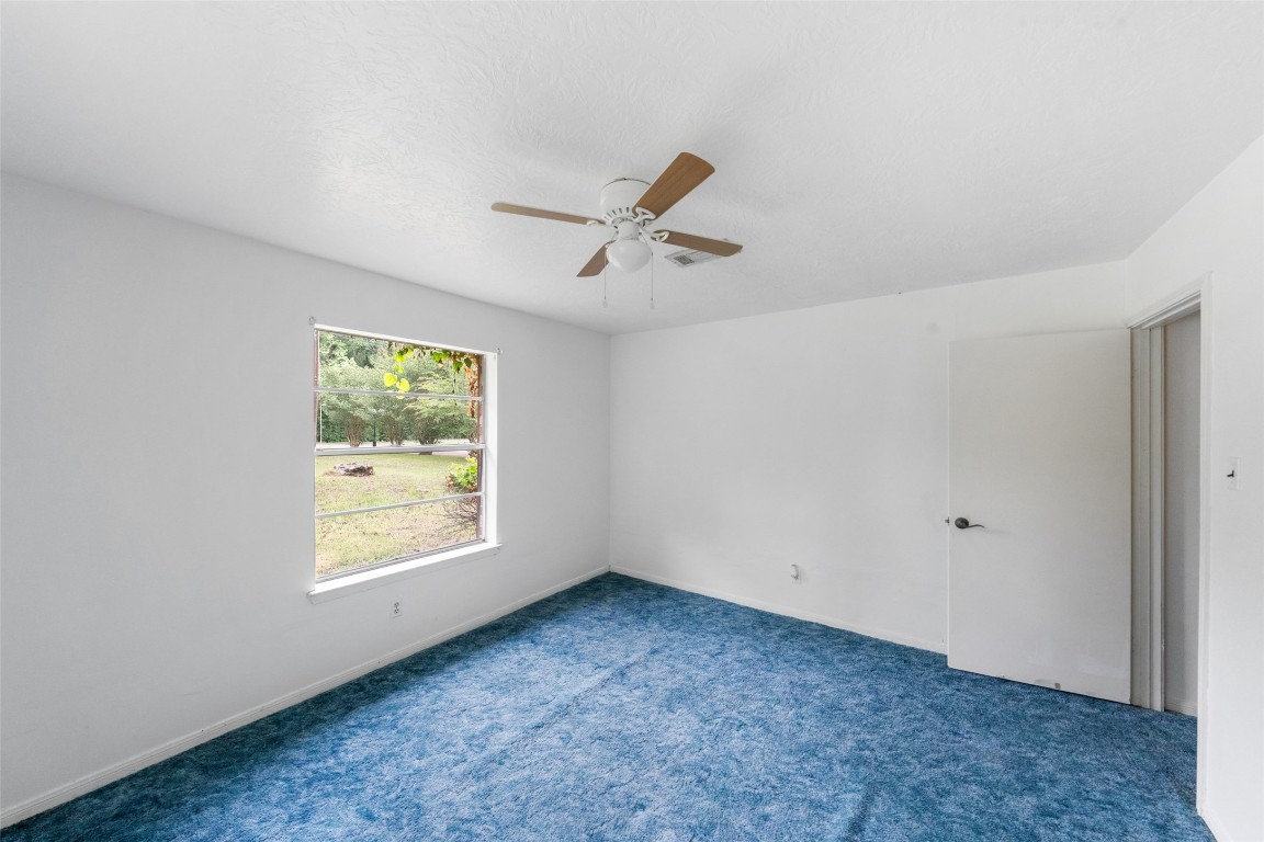 101 Walnut Coldspring, TX 77331 - Photo 19 of 37 an empty room with windows and a ceiling fan