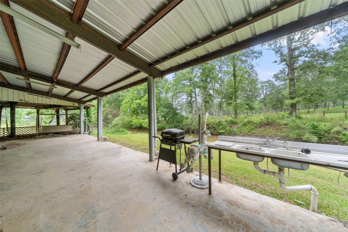 101 Walnut Coldspring, TX 77331 - Photo 27 of 37 a view of a patio with table and chairs in front of a yard with wooden fence