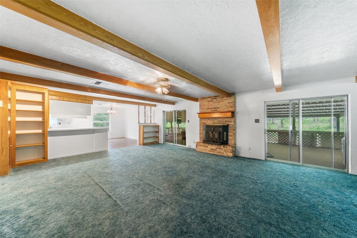 101 Walnut Coldspring, TX 77331 - Photo 7 of 37 a view of an empty room with a fireplace and a window