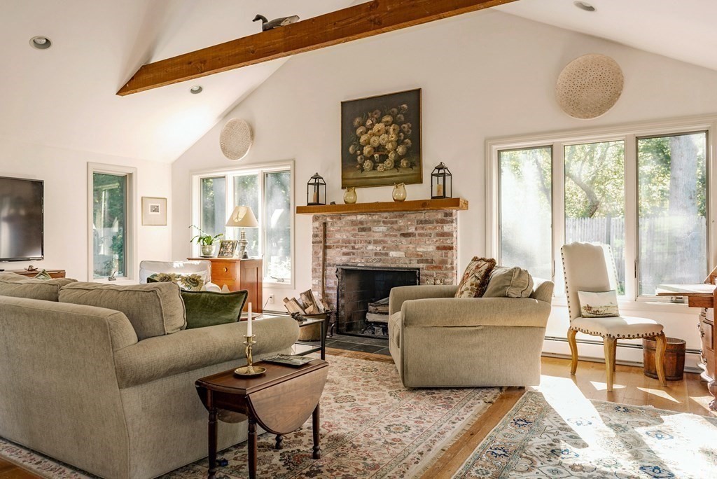239 Argilla Road Ipswich, MA 01938 - Photo 10 of 37 a living room with furniture a large window and a fireplace