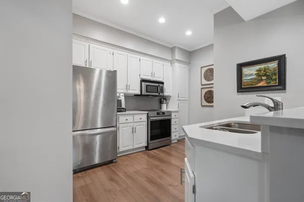 a kitchen with stainless steel appliances granite countertop a refrigerator stove top oven and sink