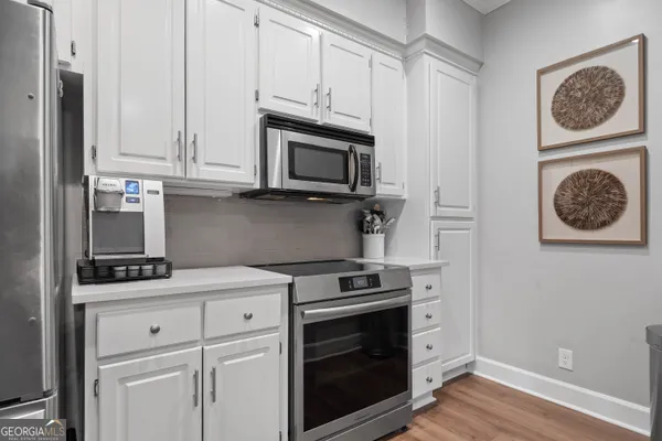 a kitchen with granite countertop white cabinets and stainless steel appliances