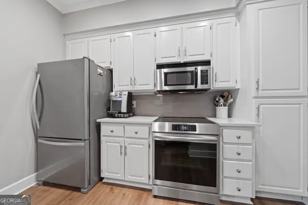 a kitchen with cabinets stainless steel appliances and a counter space