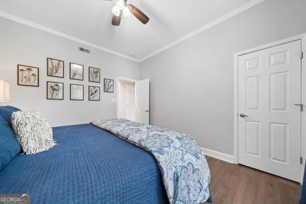 a bedroom with bed and wooden floor