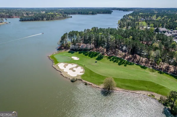 an aerial view of a house with a yard and lake view