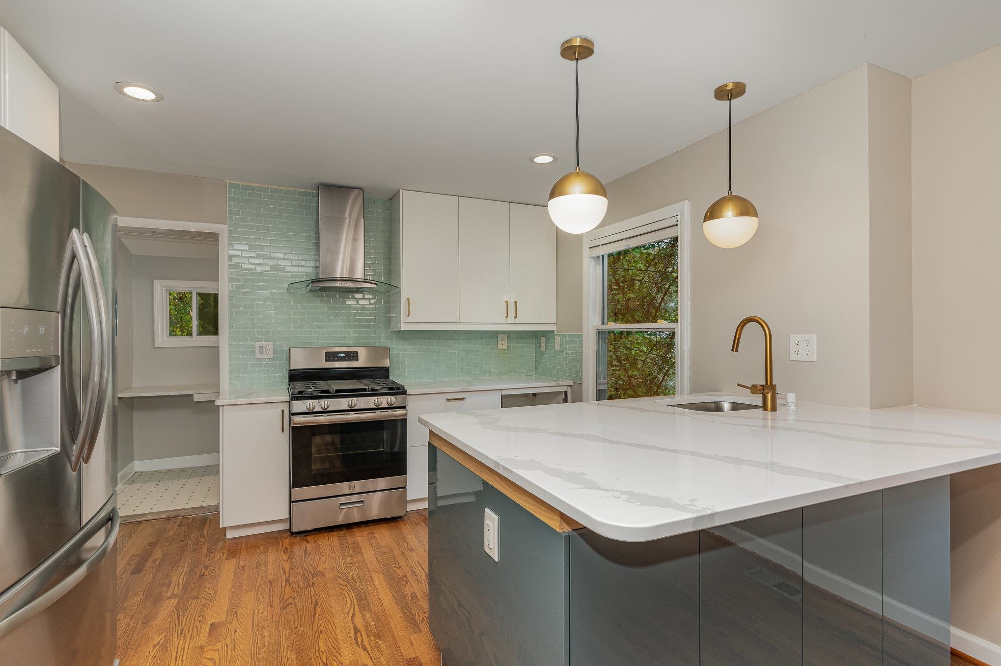 2811 Gordon Street Raleigh, NC 27608 - Photo 17 of 33 a kitchen that has a sink a stove and a wooden floor