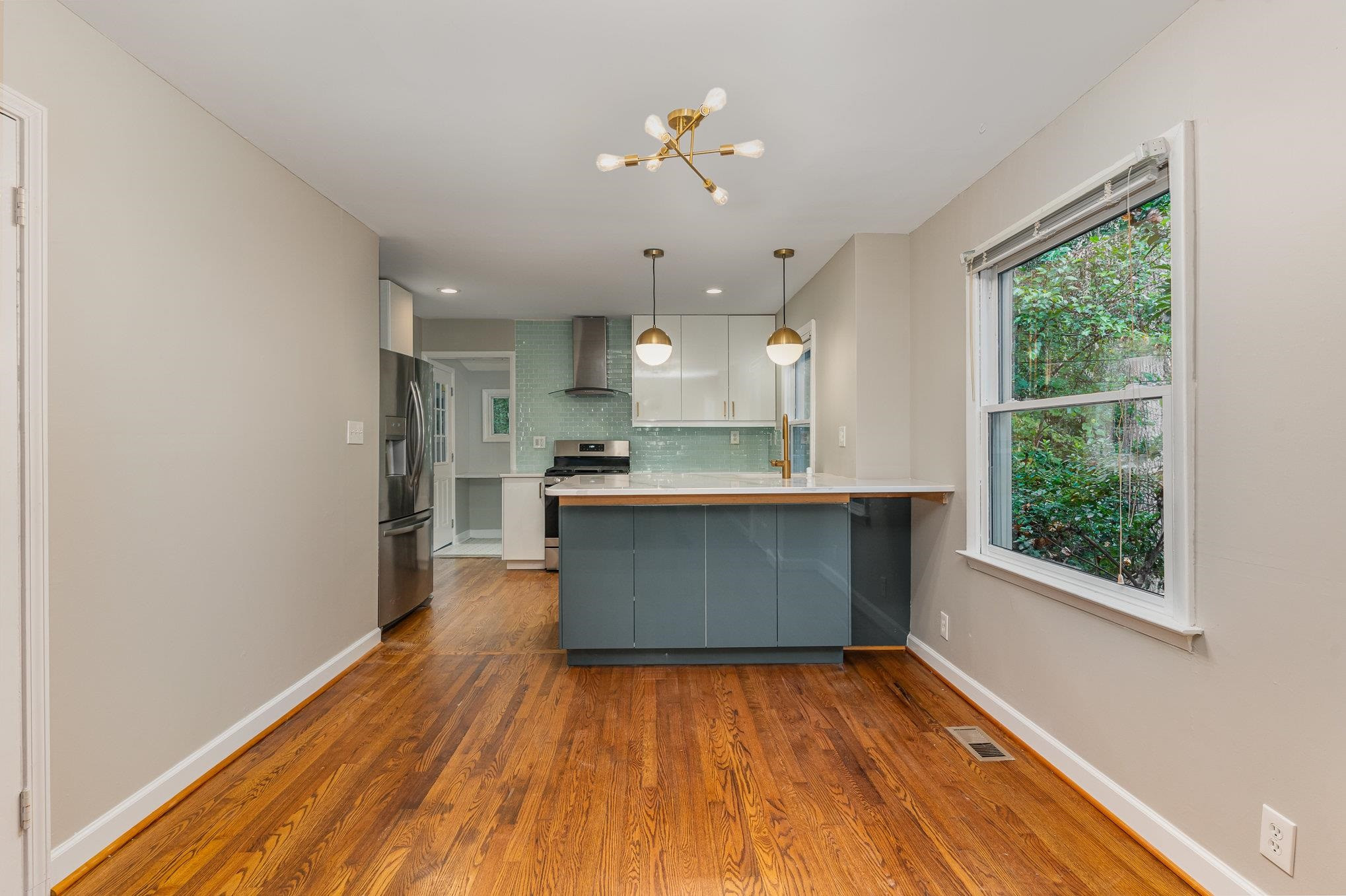 2811 Gordon Street Raleigh, NC 27608 - Photo 21 of 33 a kitchen with stainless steel appliances granite countertop a stove a refrigerator a sink dishwasher and a large oven with wooden floor