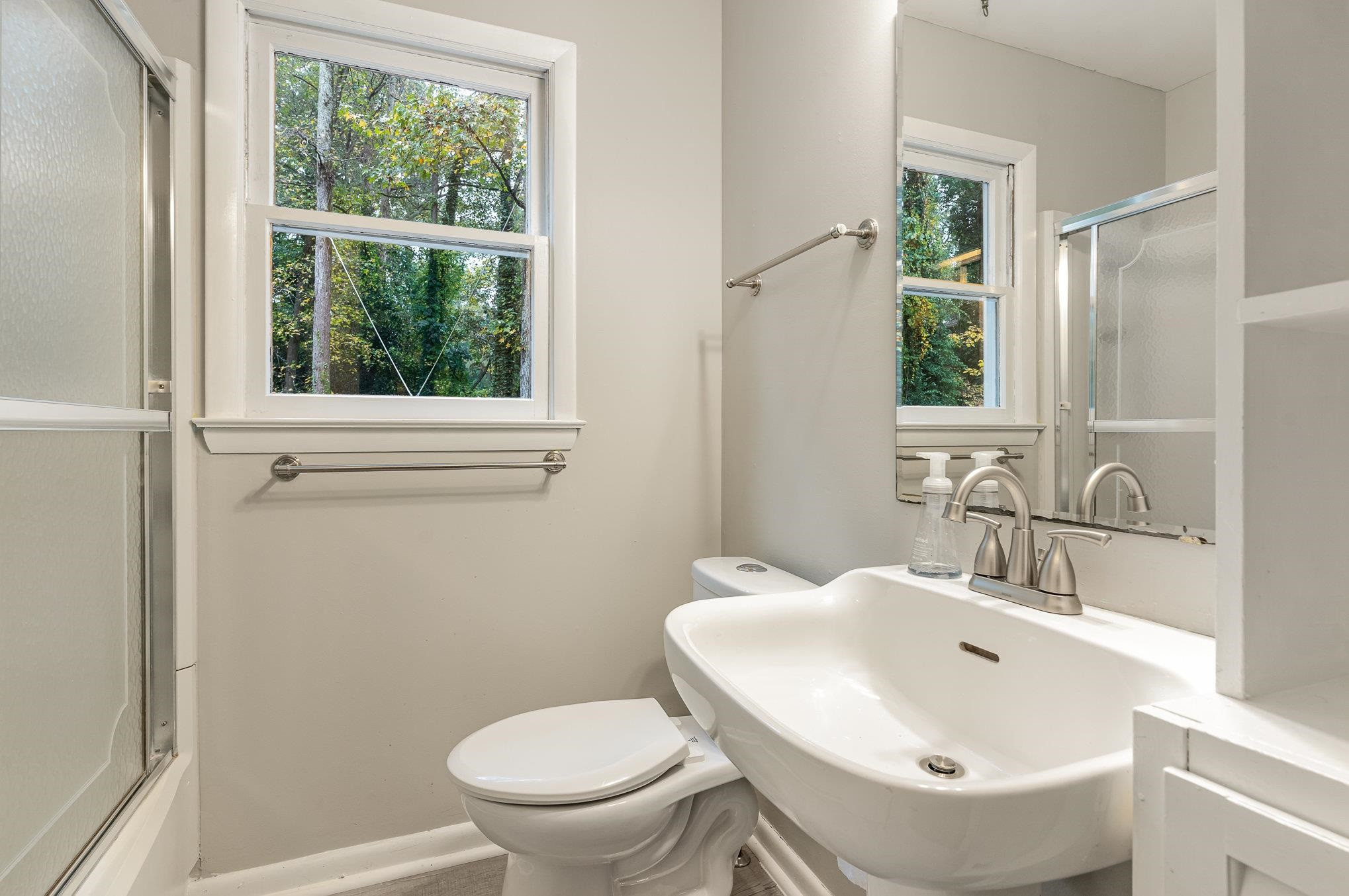 2811 Gordon Street Raleigh, NC 27608 - Photo 25 of 33 a bathroom with a sink a toilet and a mirror