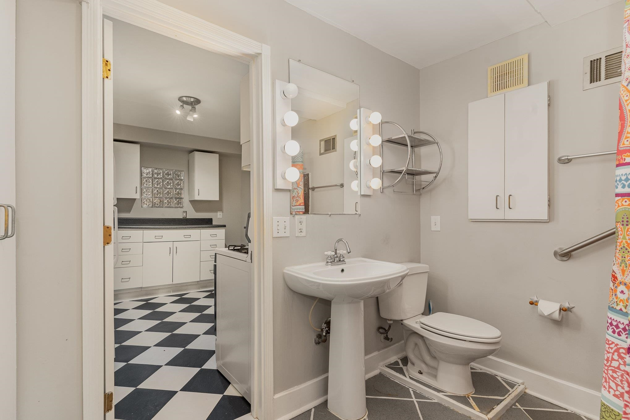 2811 Gordon Street Raleigh, NC 27608 - Photo 29 of 33 a bathroom with a sink a toilet and a mirror