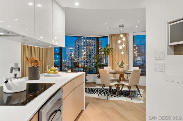 a dining hall with stainless steel appliances kitchen island granite countertop a sink and chairs