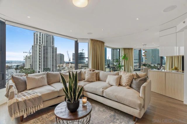a living room with furniture potted plant and a large window