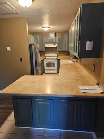 a room with kitchen island a sink a refrigerator and trees