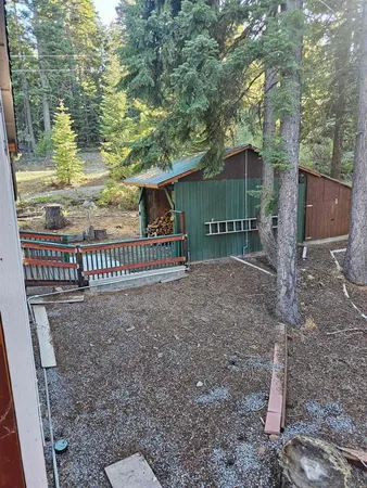 a view of a house with backyard and trees