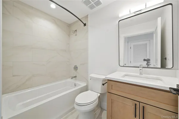 a bathroom with a sink toilet vanity and shower
