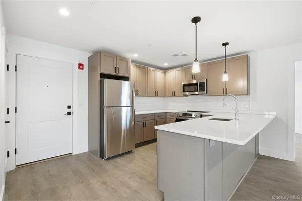 a kitchen with stainless steel appliances granite countertop a refrigerator a sink a stove a microwave and a refrigerator