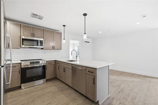 a kitchen with kitchen island a sink appliances and cabinets