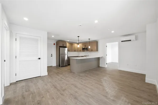 a large kitchen with a stove a sink dishwasher and a refrigerator with wooden floor