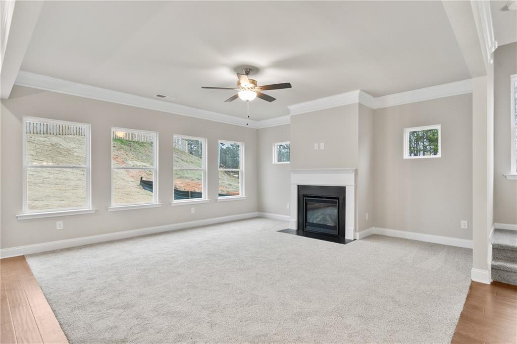 5571 Overview Drive Flowery Branch, GA 30542 - Photo 14 of 38 wooden floor fireplace and windows in an empty room
