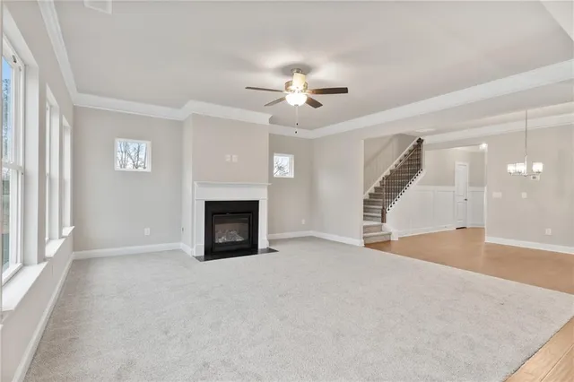 an empty room with windows and fireplace