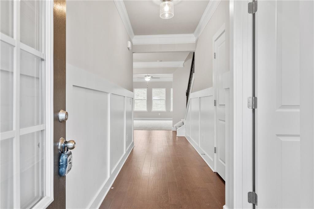 5571 Overview Drive Flowery Branch, GA 30542 - Photo 2 of 38 a view of a hallway with wooden floor and staircase