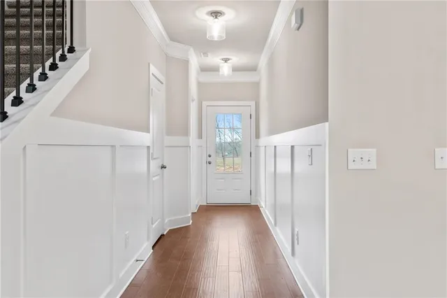 a view of a hallway with wooden floor and staircase