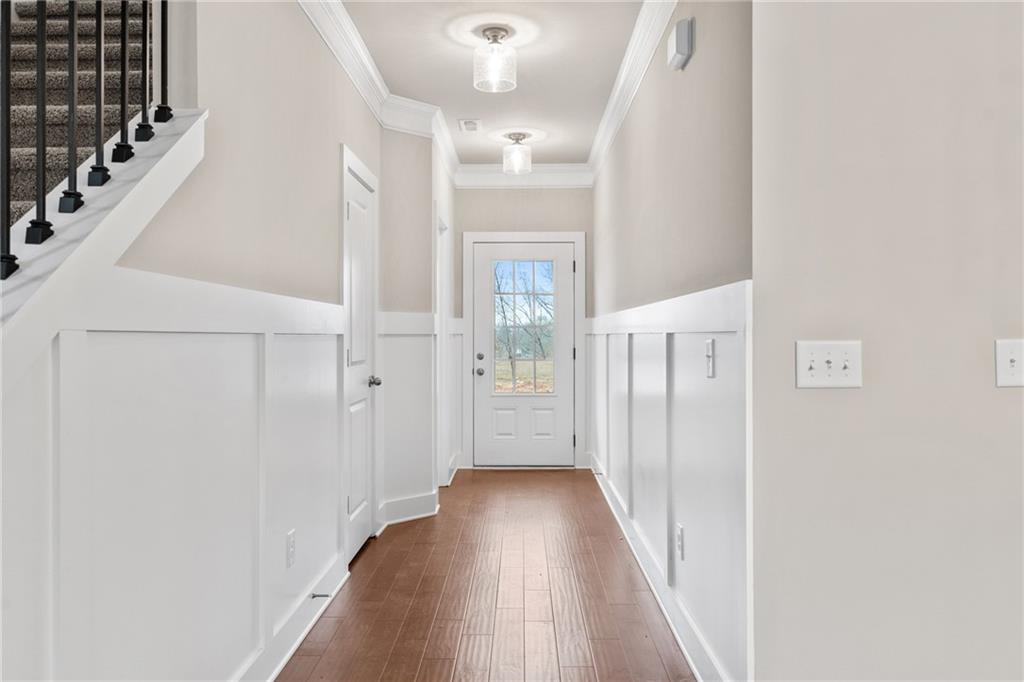 5571 Overview Drive Flowery Branch, GA 30542 - Photo 3 of 38 a view of a hallway with wooden floor and staircase