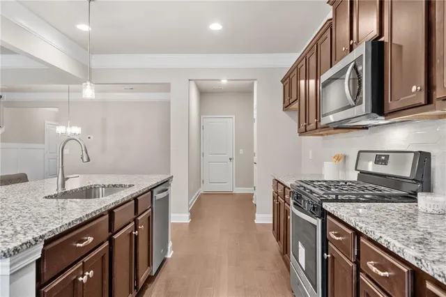 a kitchen with stainless steel appliances granite countertop a sink stove and cabinets