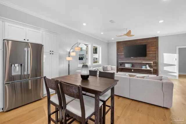 a living room with stainless steel appliances furniture a dining table and kitchen view