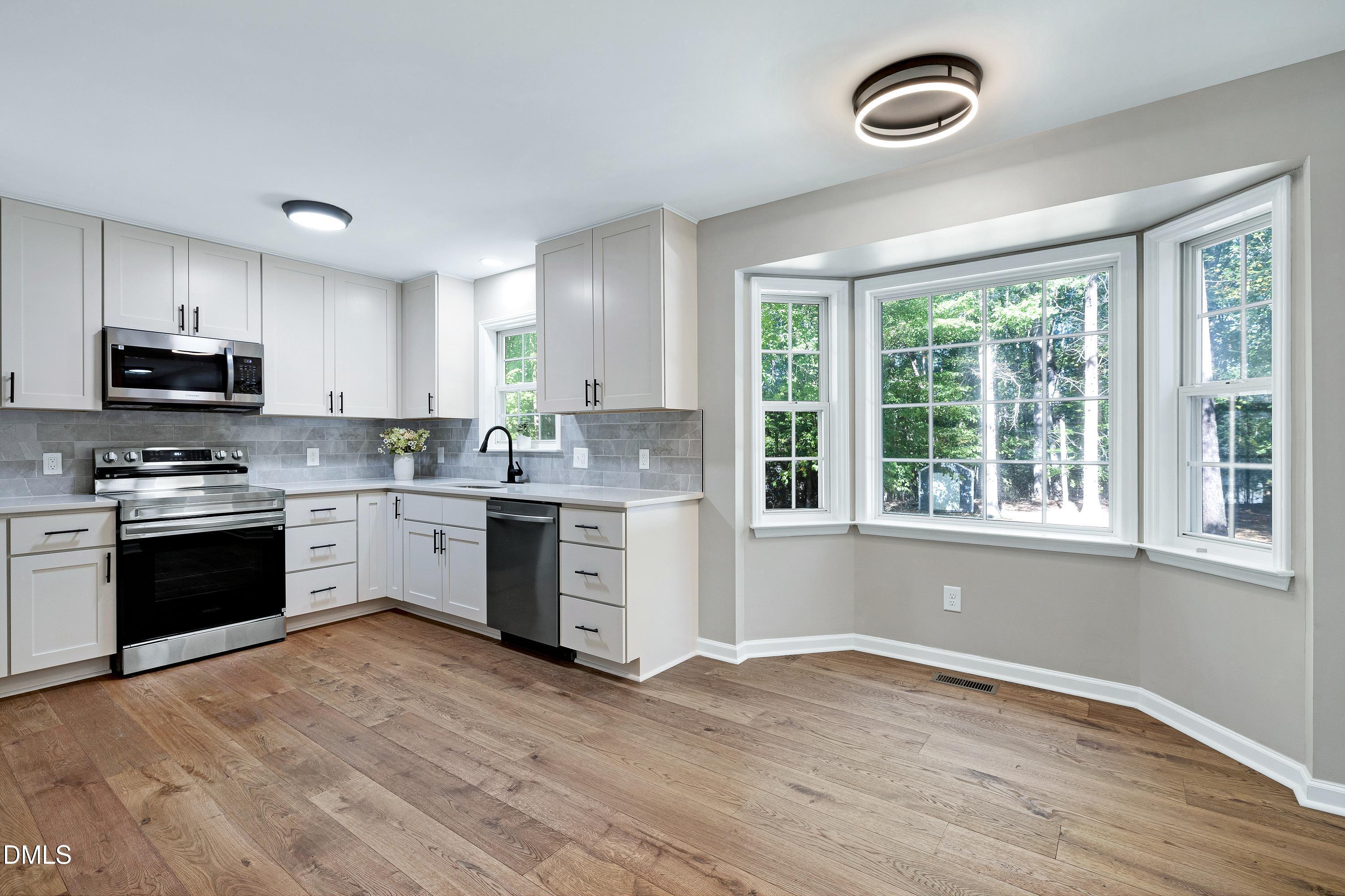 1508 Middle Ridge Drive Willow Spring, NC 27592 - Photo 12 of 56 a kitchen with granite countertop a stove top oven a sink and a window