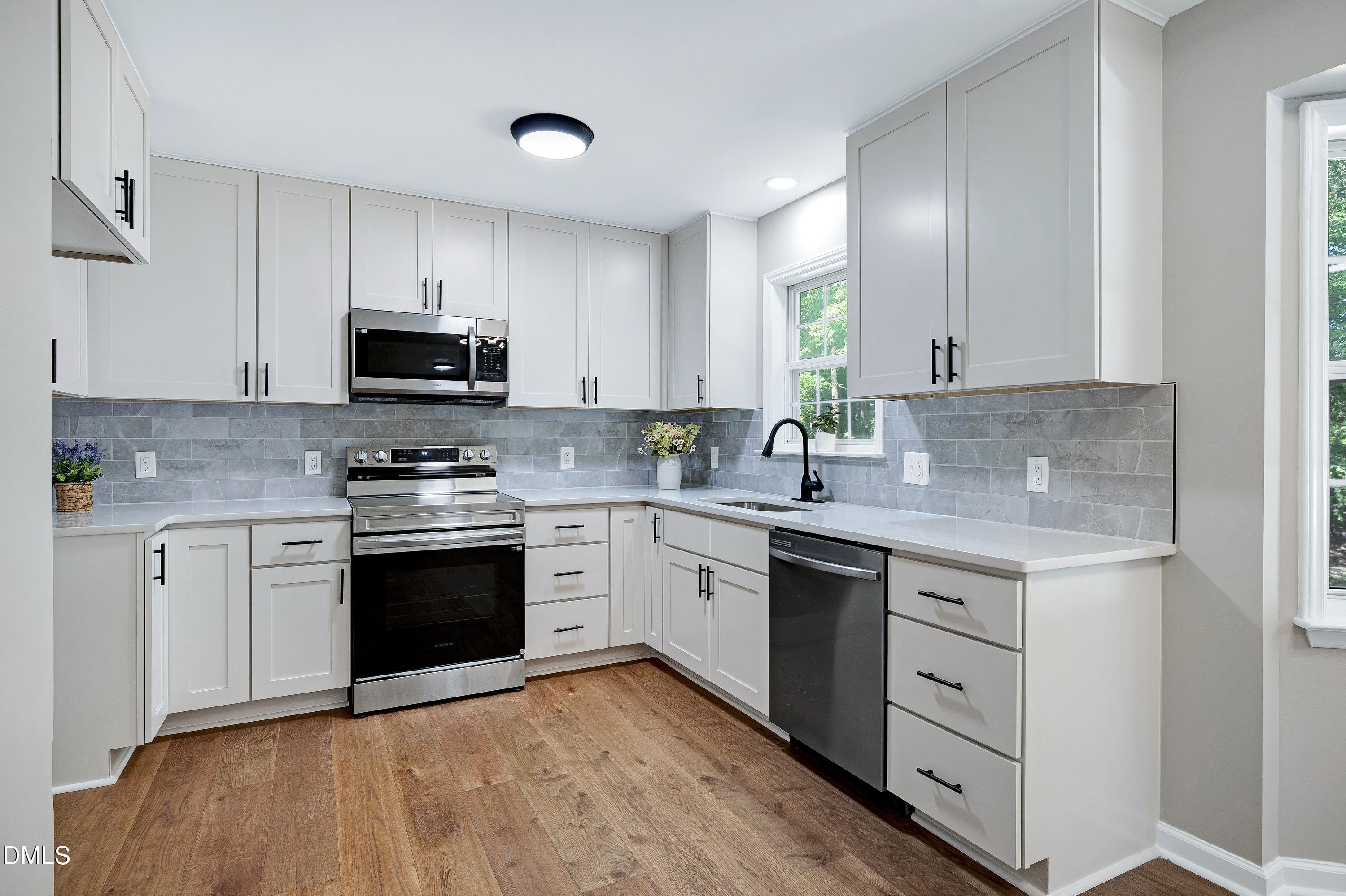 1508 Middle Ridge Drive Willow Spring, NC 27592 - Photo 13 of 56 a kitchen with stainless steel appliances granite countertop a stove a sink and a microwave
