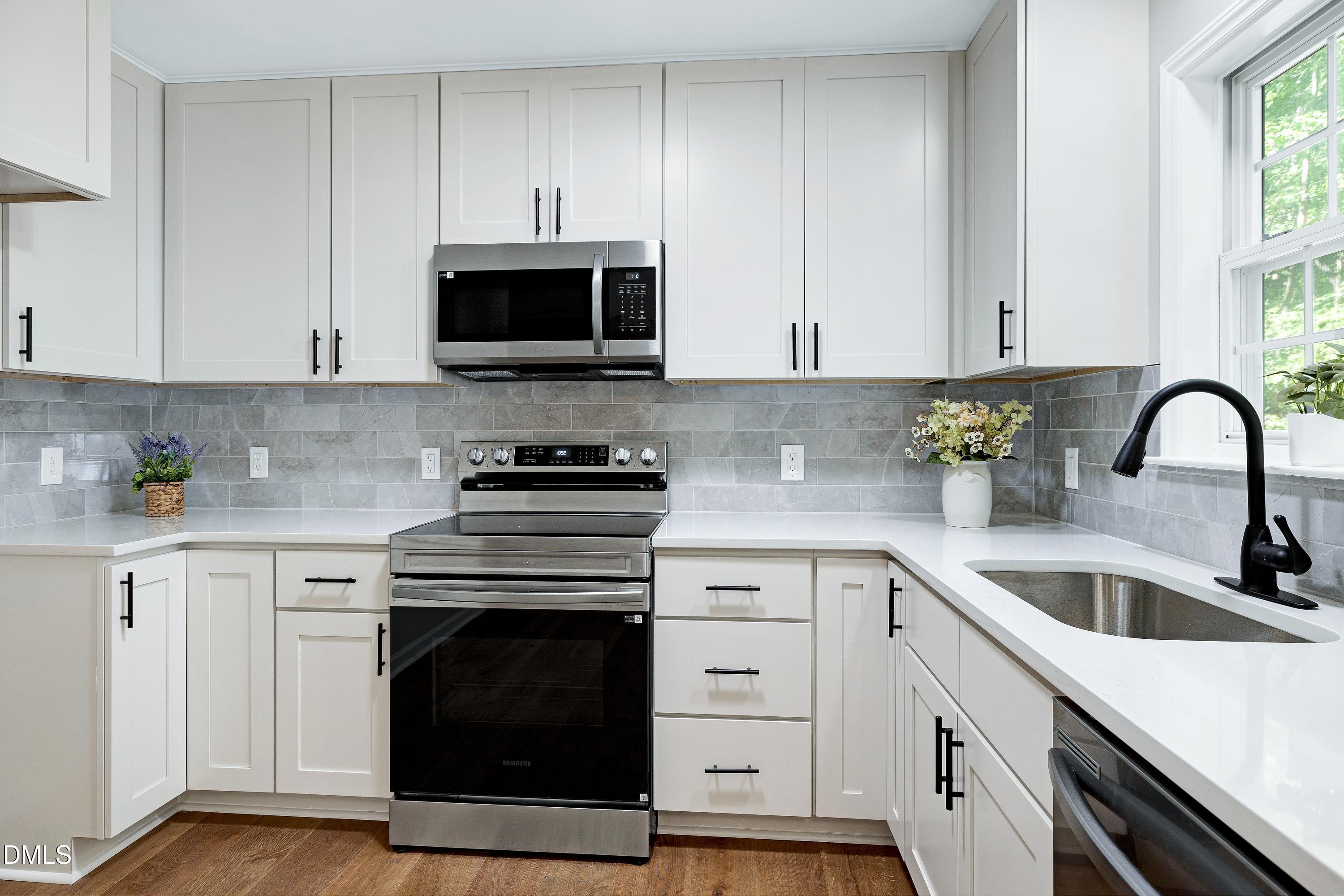 1508 Middle Ridge Drive Willow Spring, NC 27592 - Photo 14 of 56 a kitchen with stainless steel appliances granite countertop a stove a sink and a microwave