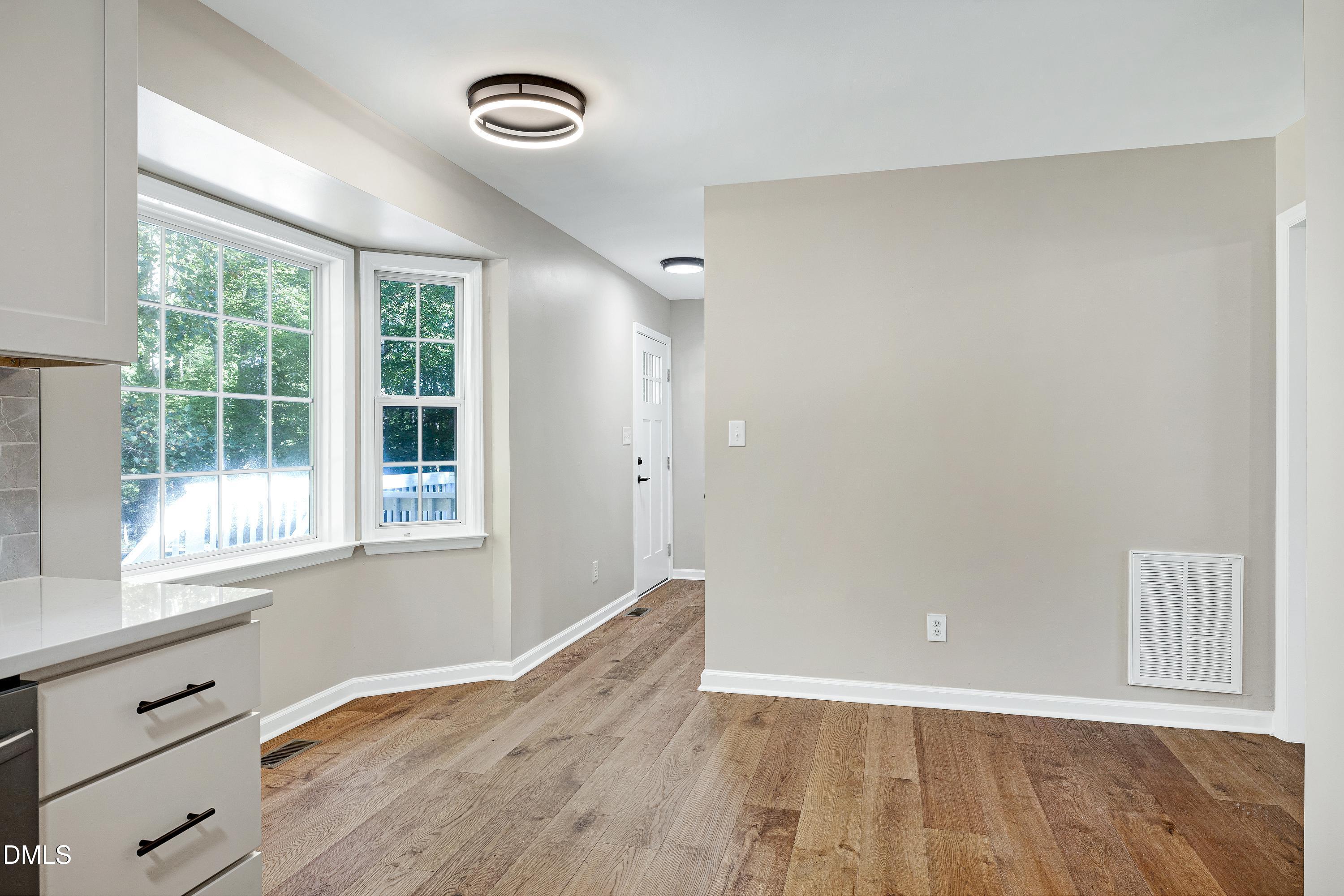 1508 Middle Ridge Drive Willow Spring, NC 27592 - Photo 16 of 56 an empty room with wooden floor and windows
