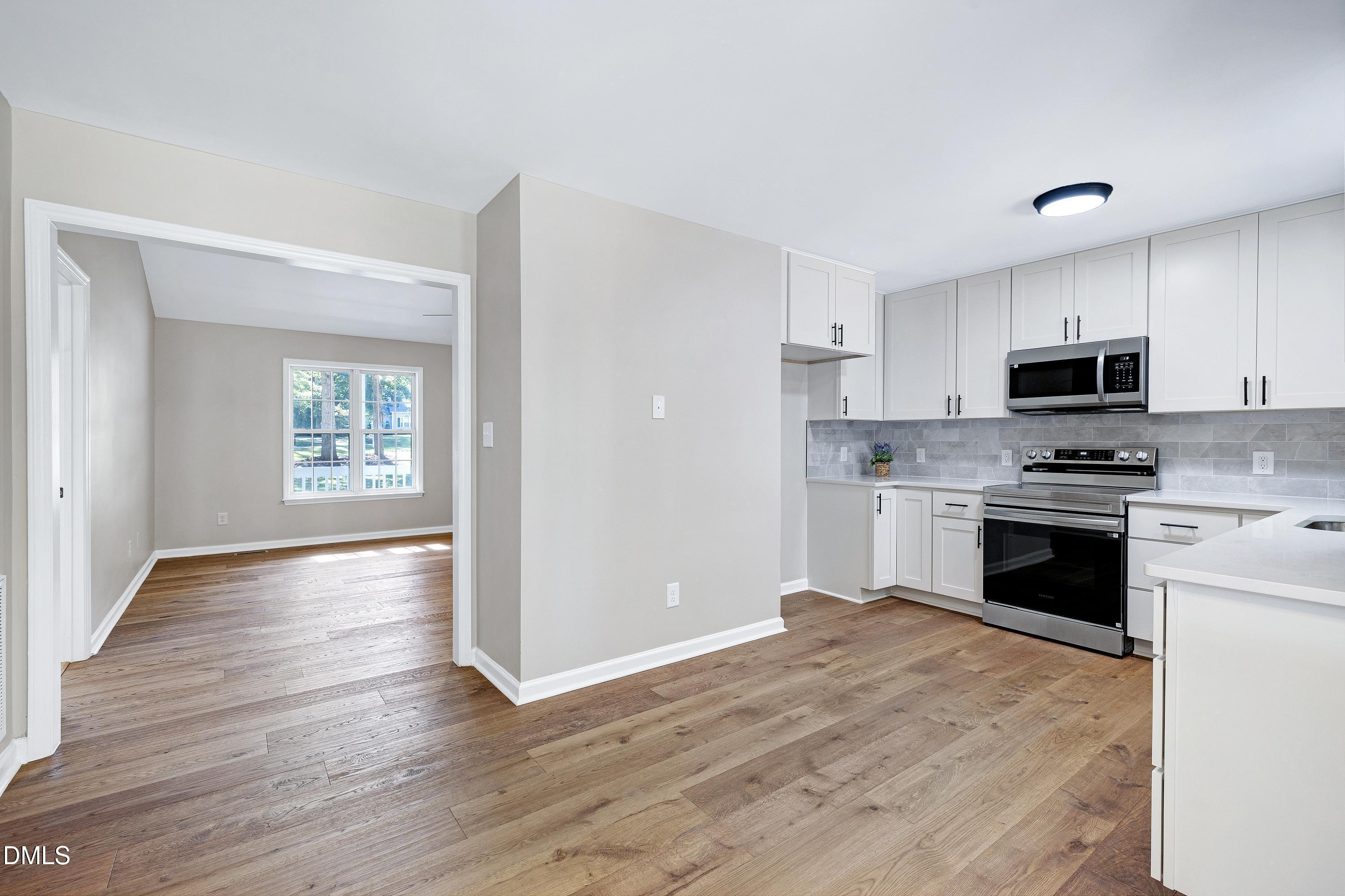 1508 Middle Ridge Drive Willow Spring, NC 27592 - Photo 18 of 56 a kitchen with granite countertop white cabinets and stainless steel appliances