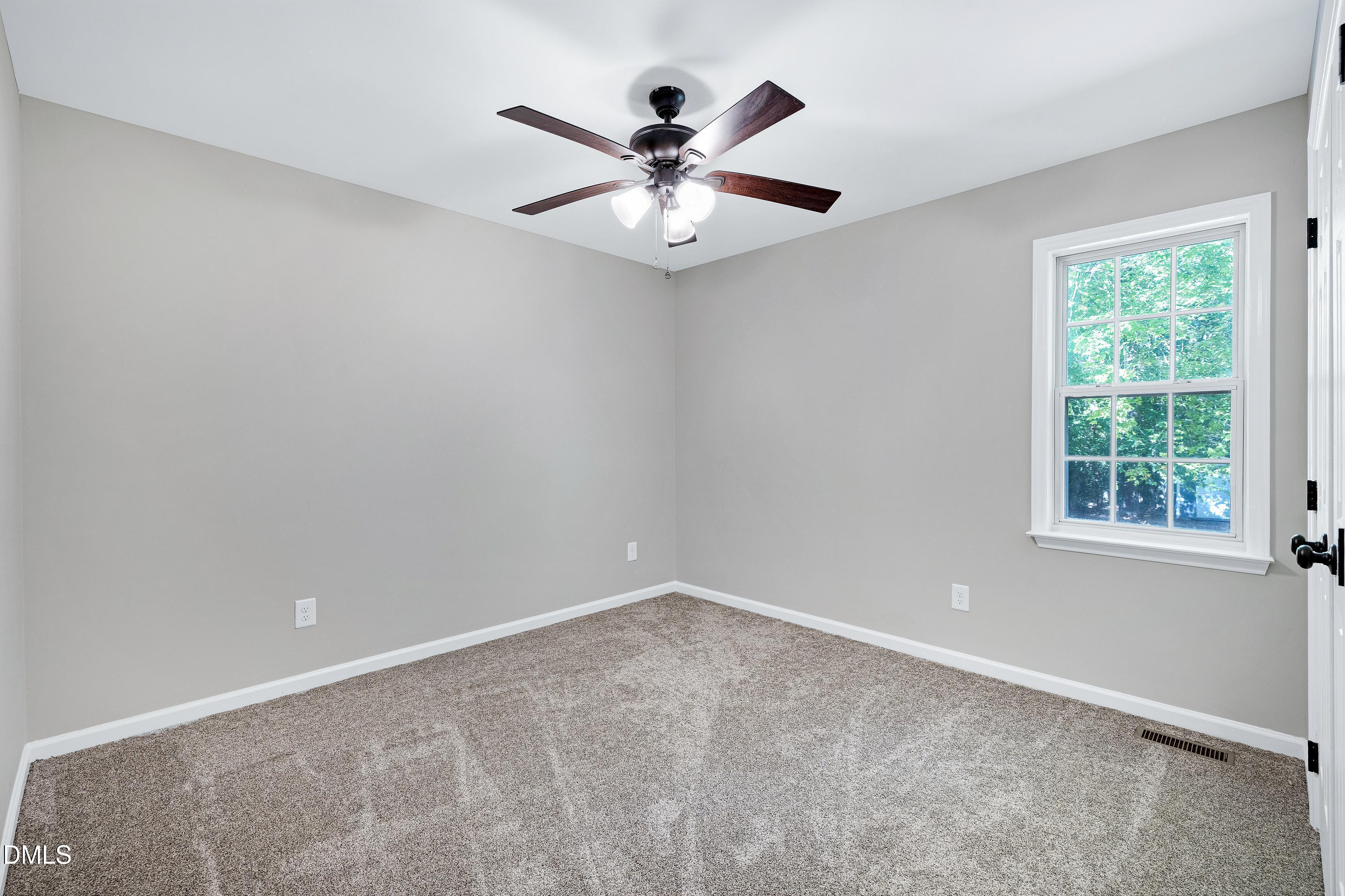 1508 Middle Ridge Drive Willow Spring, NC 27592 - Photo 28 of 56 an empty room with a window and a fan