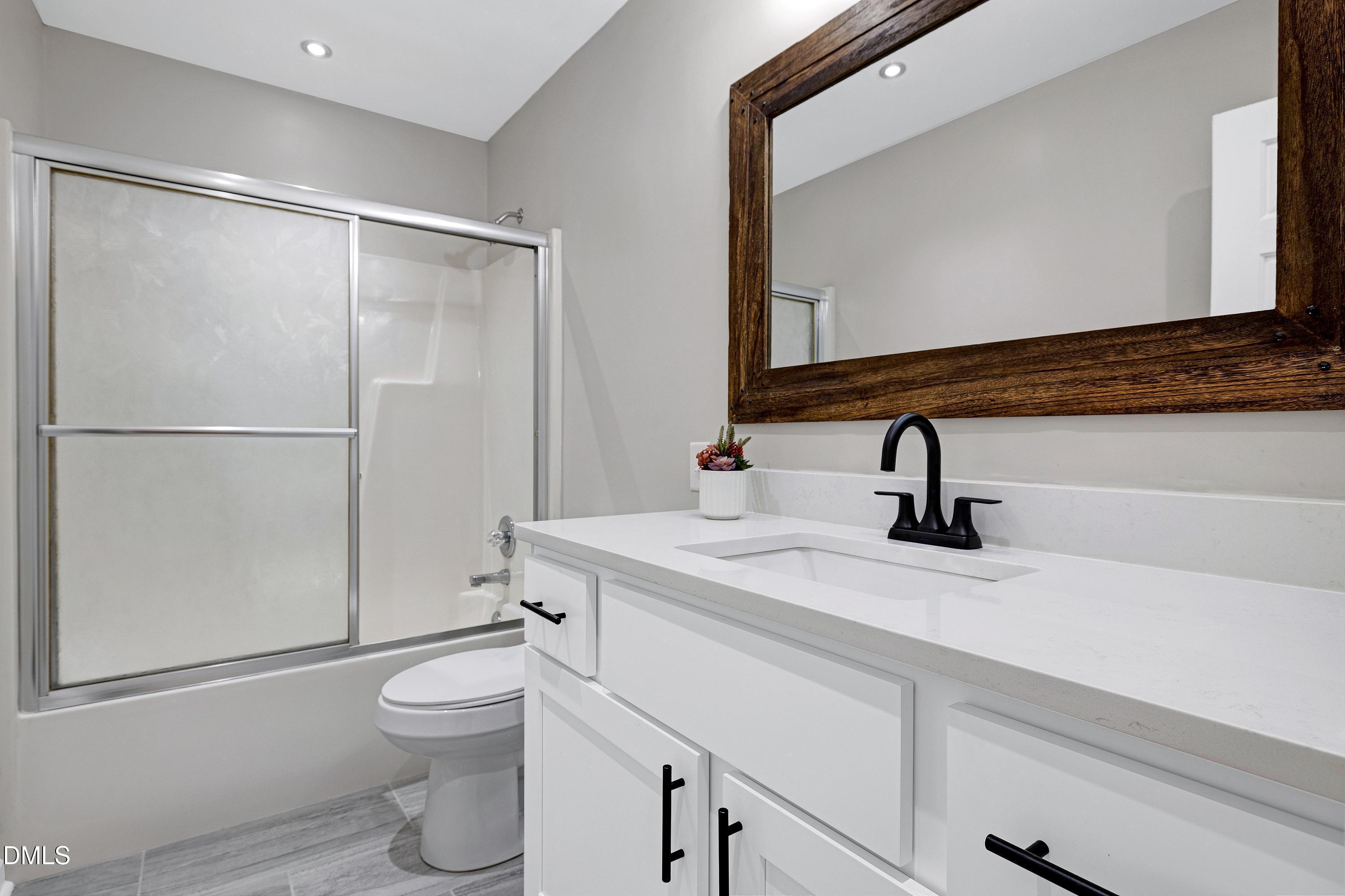 1508 Middle Ridge Drive Willow Spring, NC 27592 - Photo 30 of 56 a bathroom with a sink a toilet and a mirror