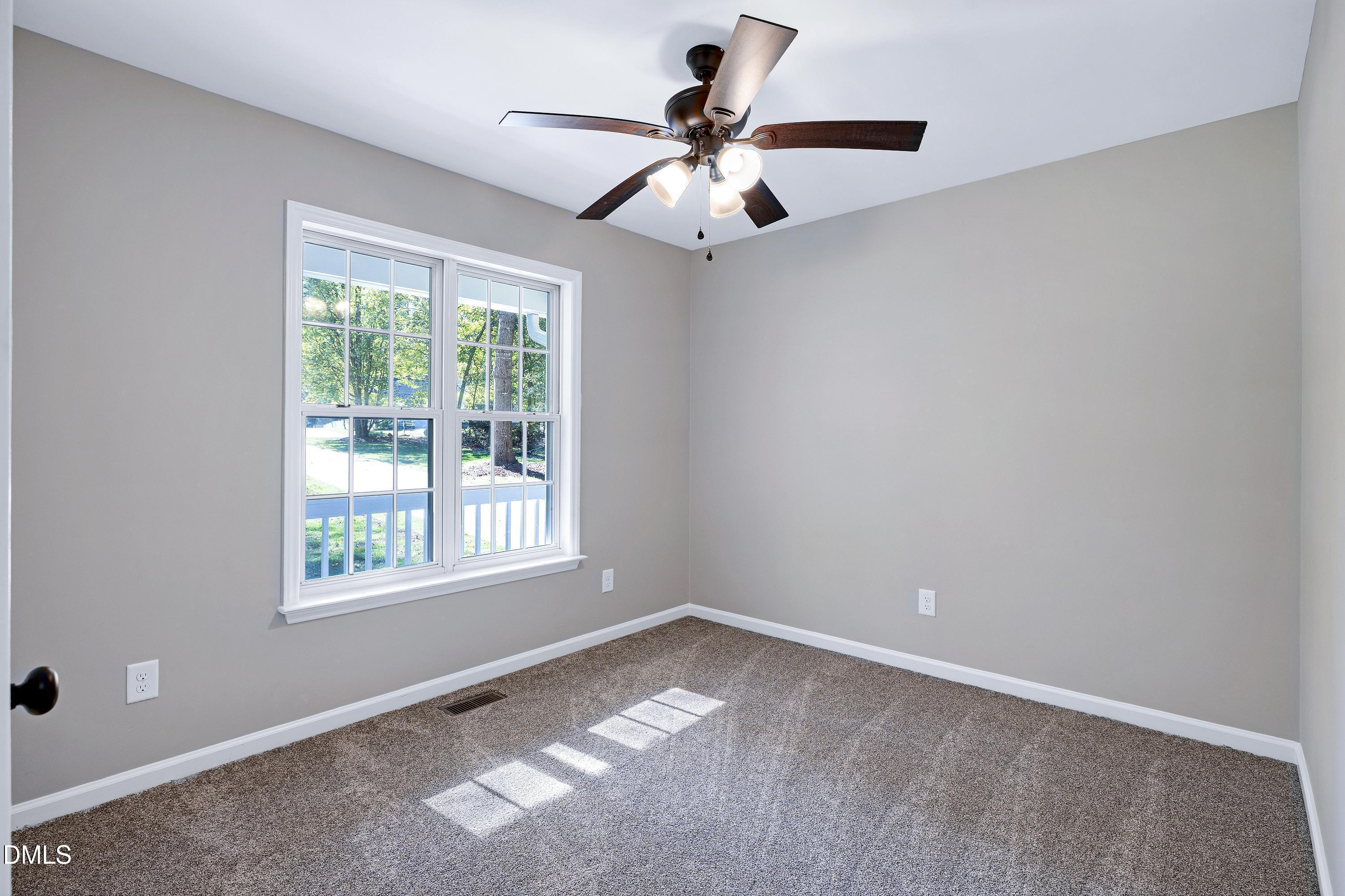 1508 Middle Ridge Drive Willow Spring, NC 27592 - Photo 31 of 56 an empty room with a window and a fan