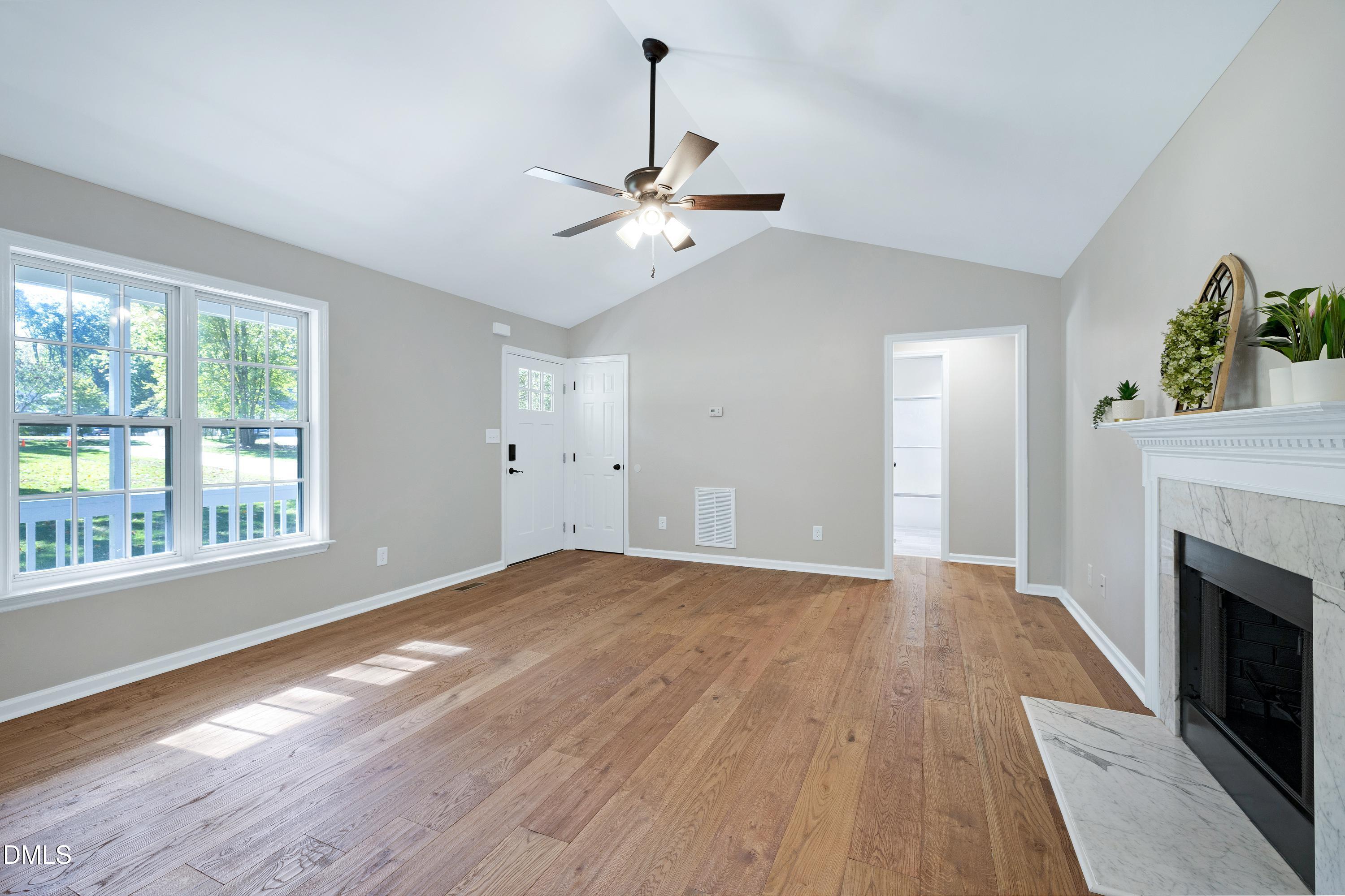 1508 Middle Ridge Drive Willow Spring, NC 27592 - Photo 9 of 56 a view of an empty room with wooden floor fireplace and a window