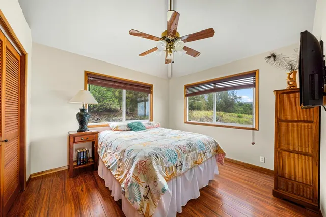 a bedroom with a bed and a flat tv screen on dresser
