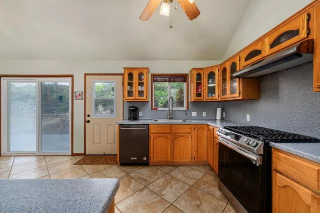 a kitchen with stainless steel appliances granite countertop a stove a sink and a microwave