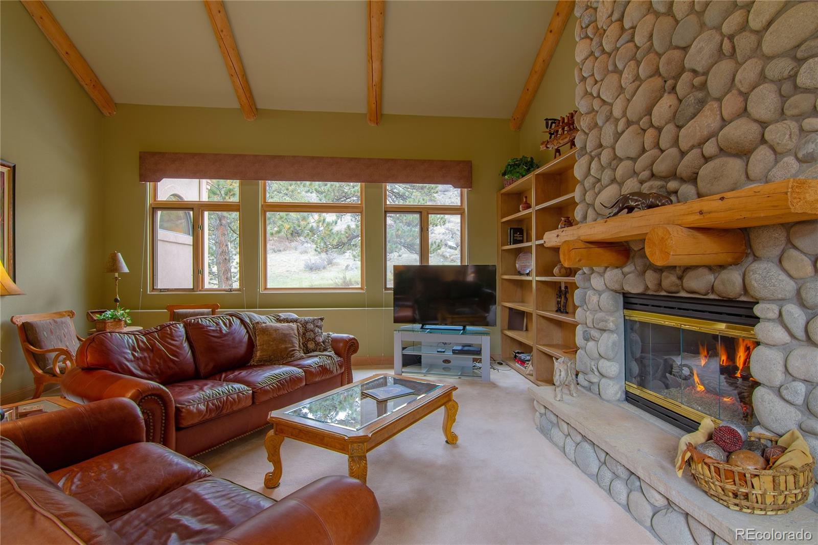 974 Spring Ranch Drive Golden, CO 80401 - Photo 11 of 35 a living room with furniture a fireplace and a flat screen tv