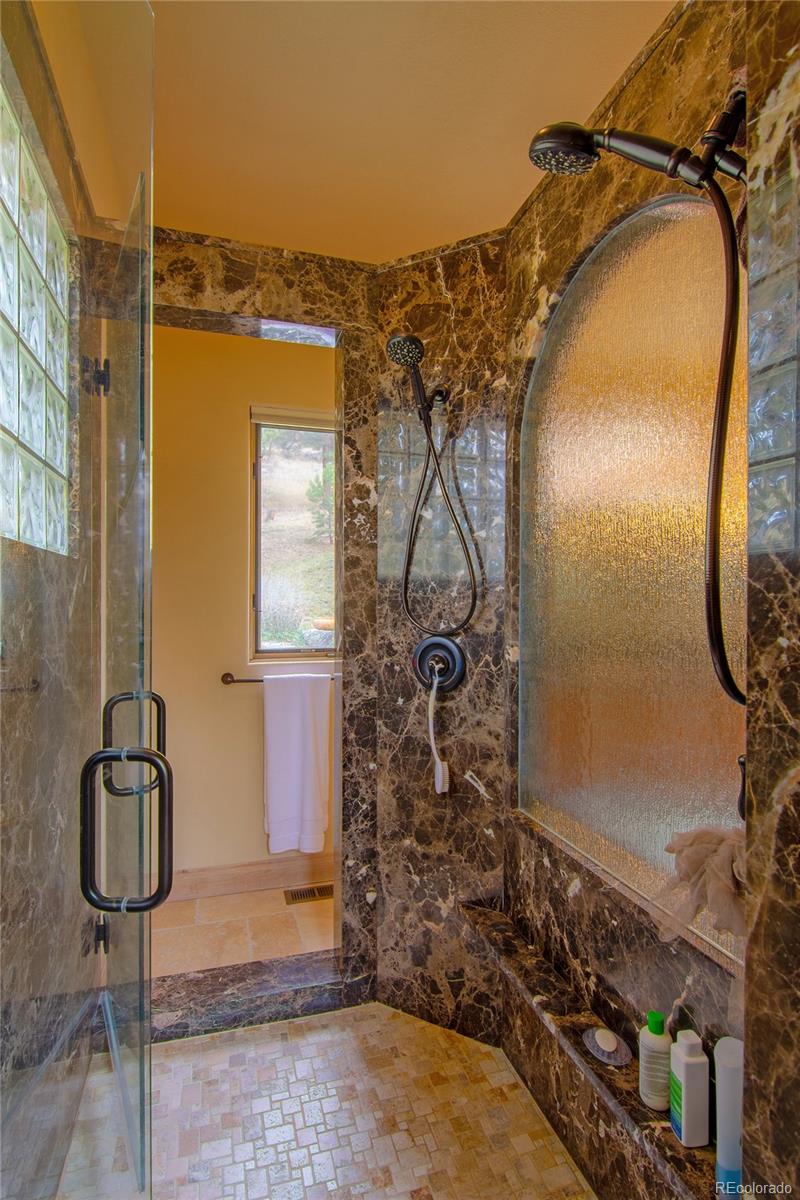 974 Spring Ranch Drive Golden, CO 80401 - Photo 18 of 35 a bathroom with a granite countertop shower and a mirror